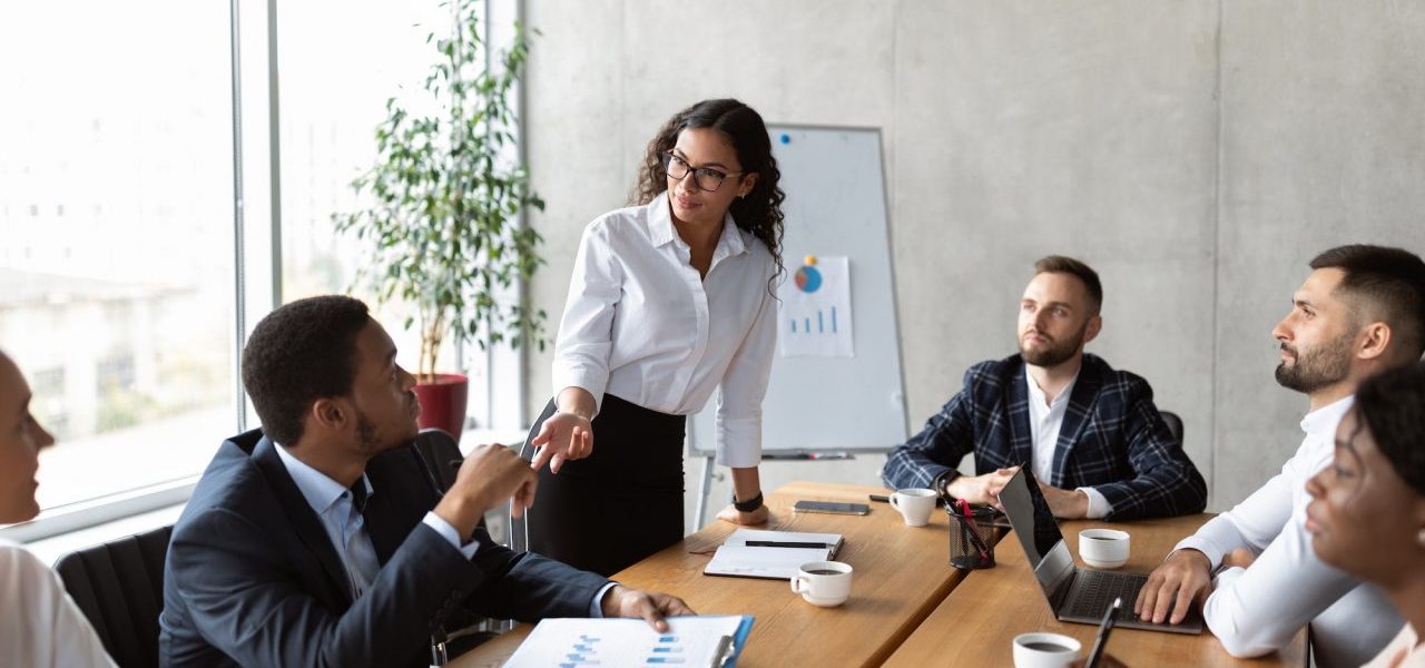 businesswoman-on-business-meeting-talking-with-colleagues-standing-in-office.jpg